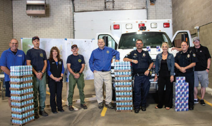 photo by Kim Cameron B&K Distribution donated 200 cases of canned water and 20 cases of Red Bull for those involved in firefighting efforts. On hand to accept the generous gift were representatives from Grand County EMS, Kremmling Fire Protection District, Grand County Coroners, Kremmling Police Department and the Kremmling Chamber. (L to R) Allen Pulliam, Brady Mathis, Tawnya Bailey, Tony Tucker, Christian Hornbaker, Todd Willson, Tara Sharp, Jamie Lucas and B & K representative Peter Holmes. Interestingly, during the firefighting efforts there were so many donations, Chamber Executive Director Tara Sharp was asked to help manage the donations. Many of the federal fightfighters were on regimented diets and could not accept donations; however, the local first responders were able to utilize the donations. There is currently a plan to thank all our first responders with a community dinner in the near future.