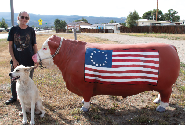 photo by Kim Cameron | Gary Vocate poses with his dog, Kenai, and the iconic steer, Mr. America. Gary refurbished Mr.America so he could become Kremmling’s landmark once again.