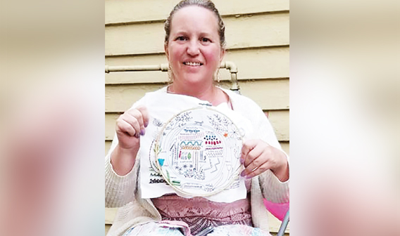 Sarah Villa and her embroidery sample.