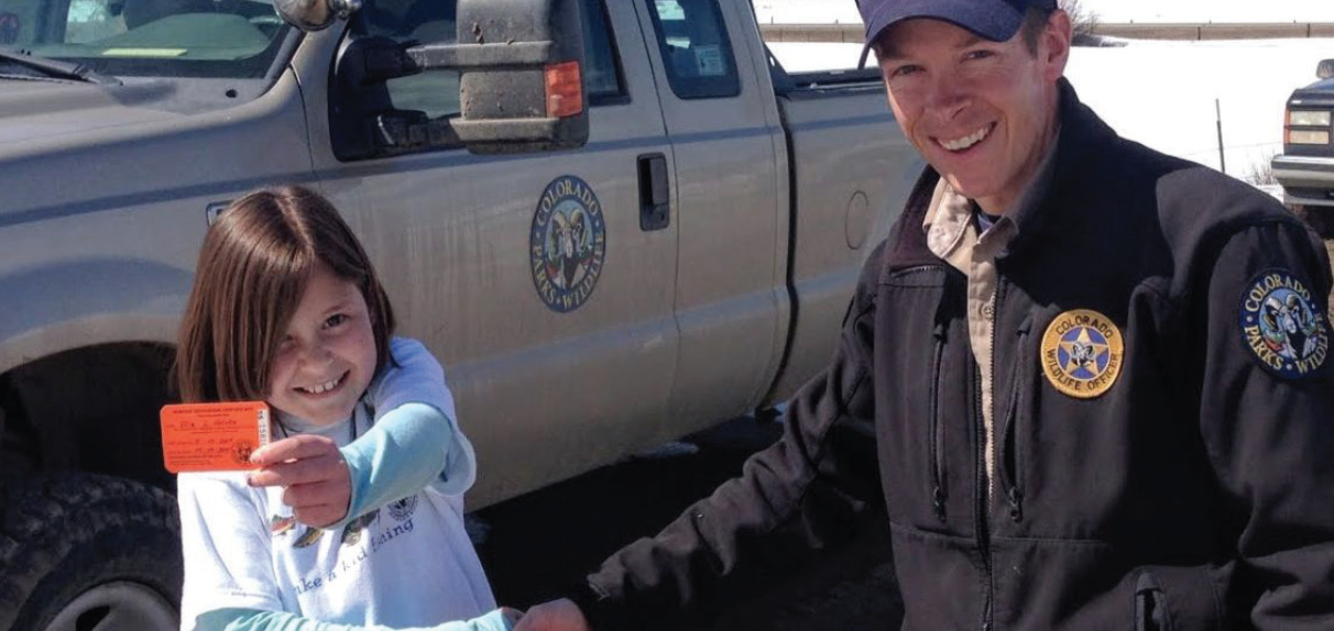 Jeromy Huntington congratulates a future hunter who just completed her hunter safety class.