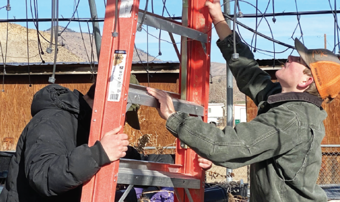Andrew Pecotte and Ollie Bergman help put new plastic wrap on the Greenhouse.